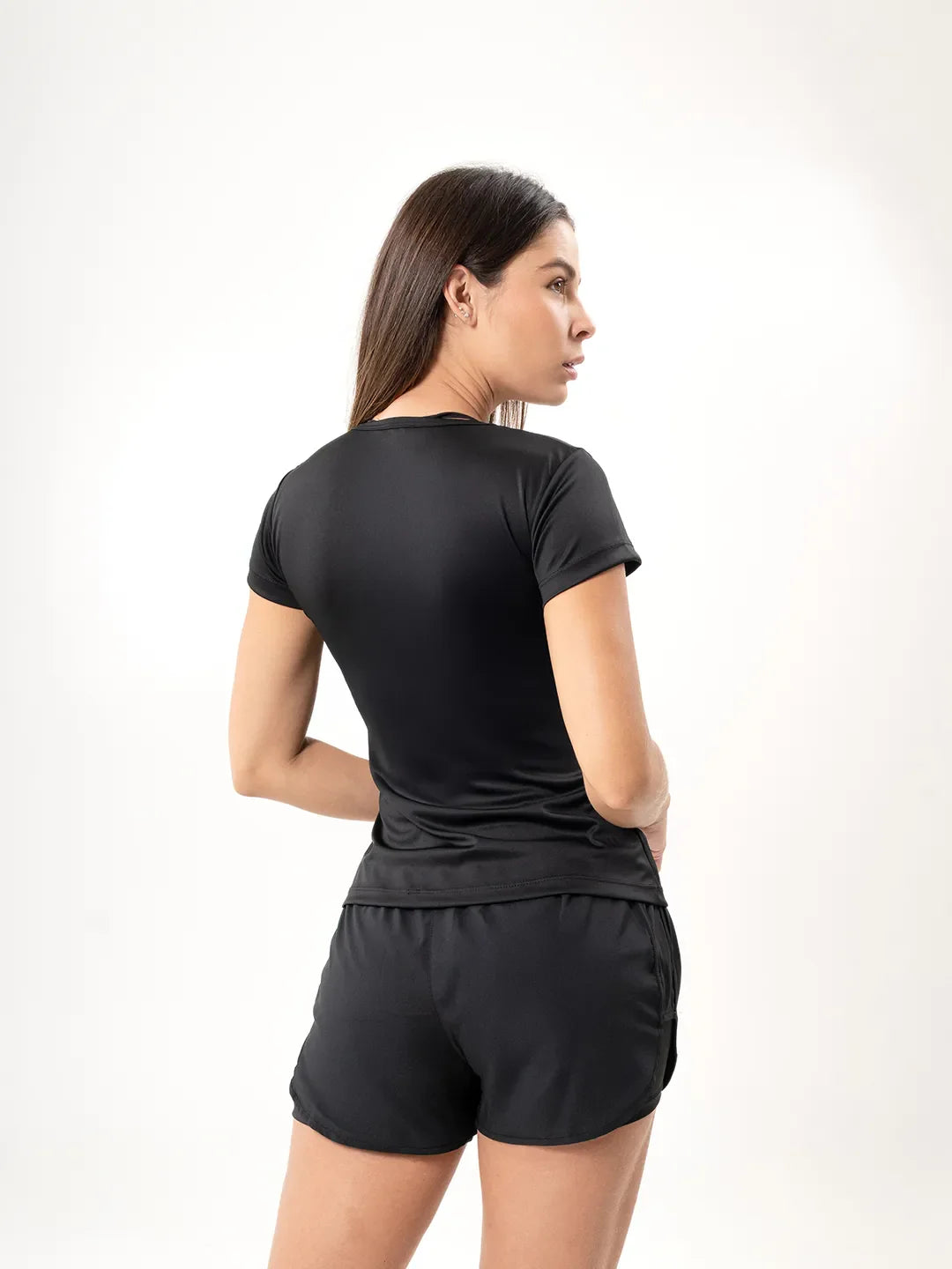 Vista lateral posterior media distancia camiseta deportiva negra mujer TENFIT