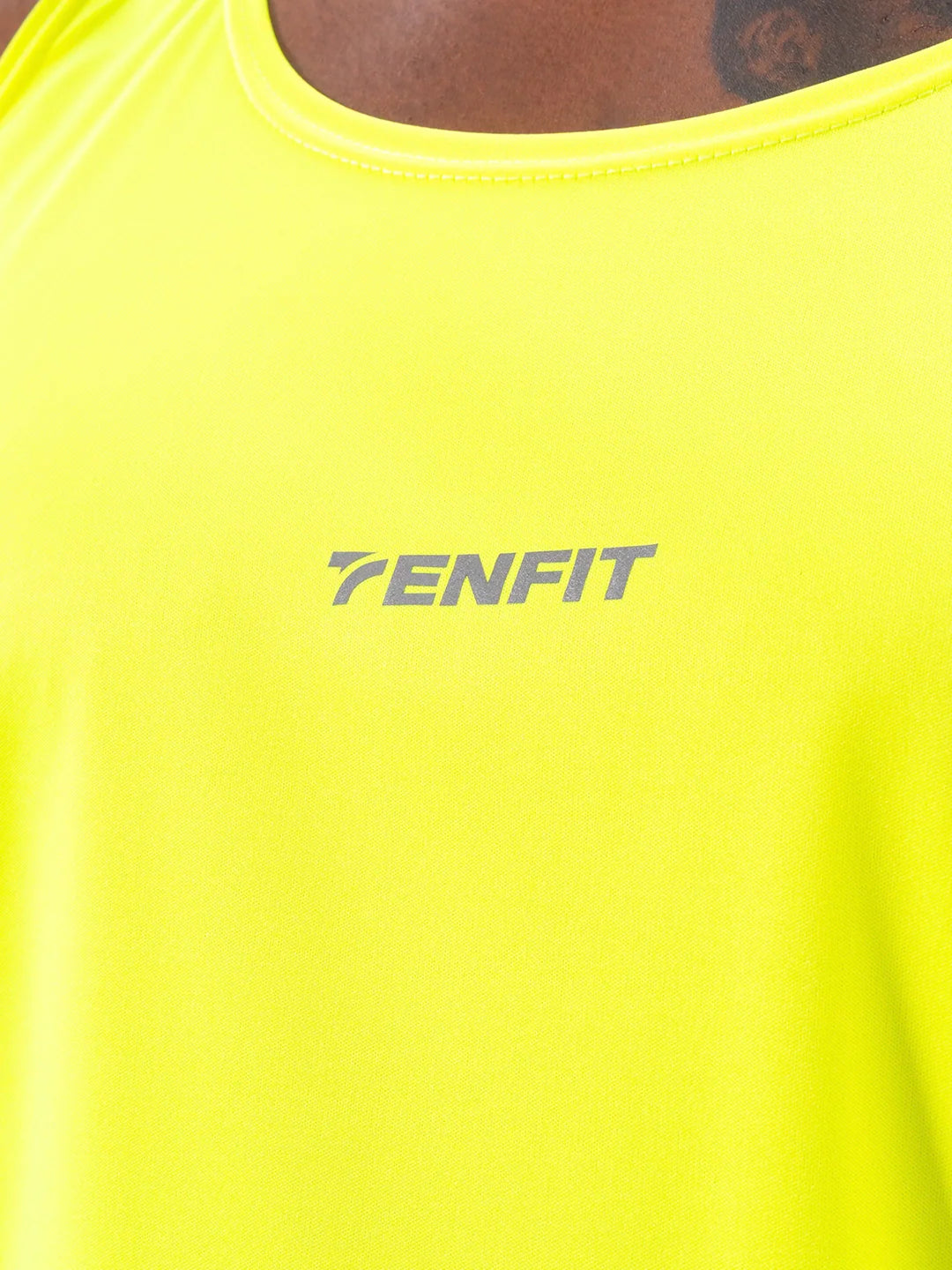Detalle logo TENFIT camisilla amarillo neón deportiva hombre
